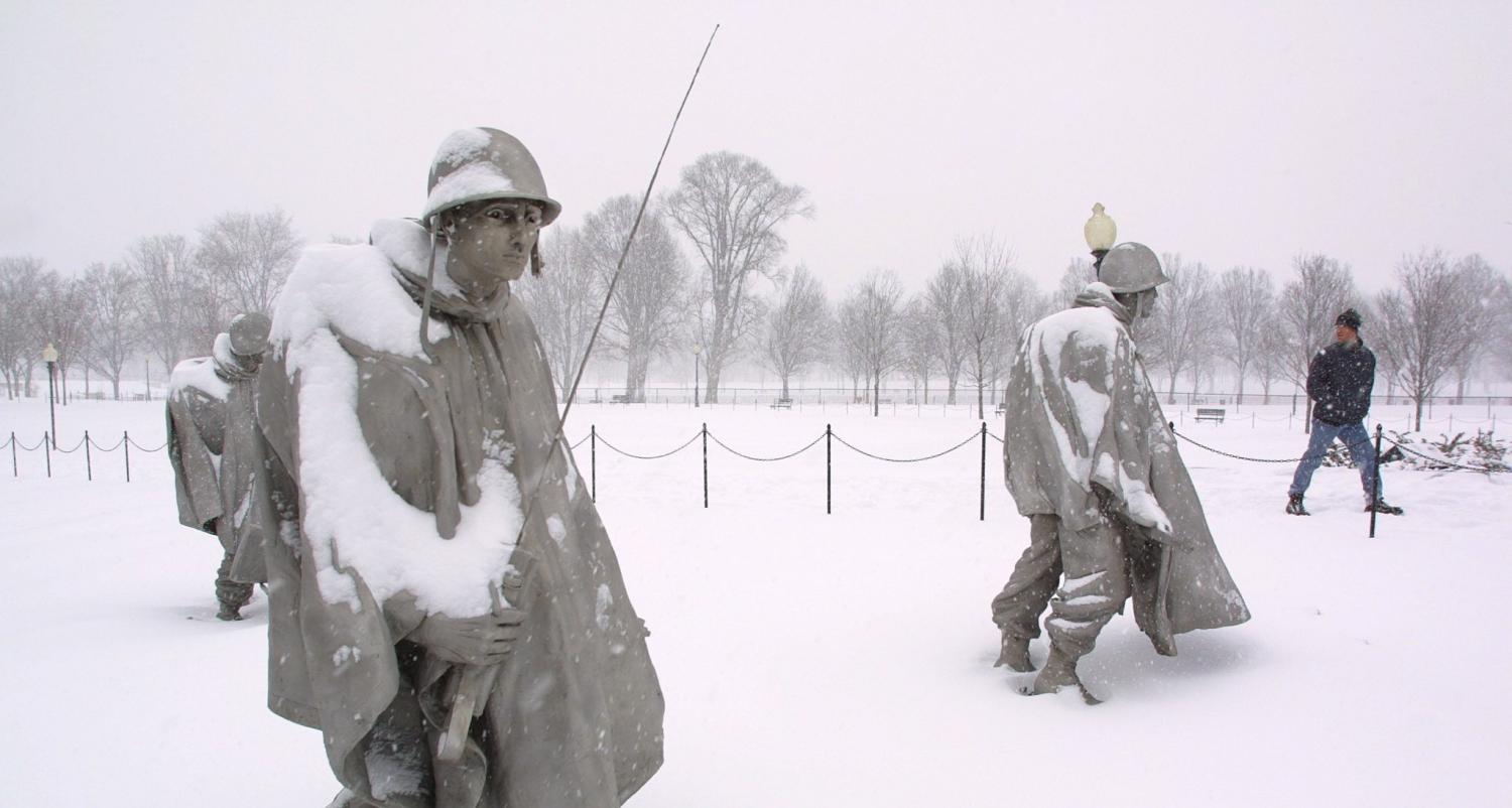 A visitor walks by snow covered Korean War Veterans Memorial sculptures