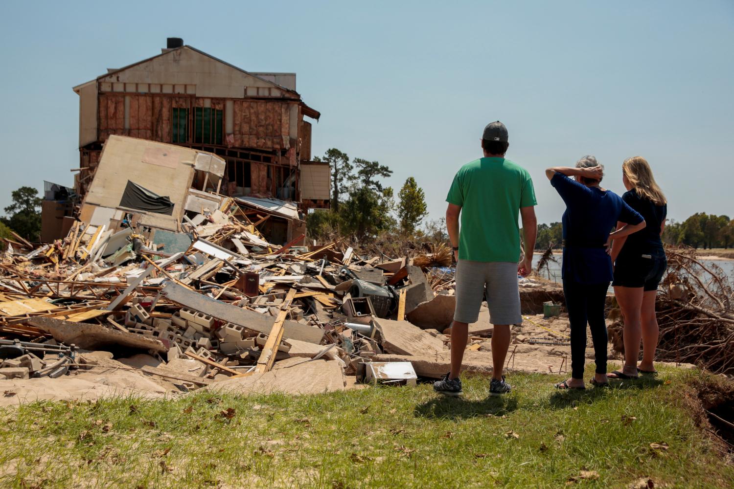 Charlie Briganti, is joined by his mother-in-law, Juanita Hurt, and wife, Jenny Briganti as they look at where their townhouse once stood on the San Jacinto River in the aftermath of tropical storm Harvey in Kingwood, Houston, Texas, U.S. September 9, 2017. REUTERS/Chris Aluka Berry