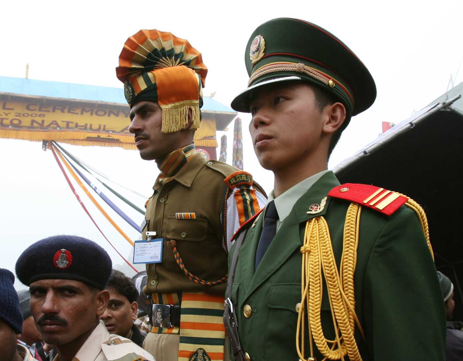 Chinese and Indian border guards stand at the Nathu La mountain pass, between Tibet and the tiny northeastern Indian state of Sikkim, July 6, 2006. Asian giants India and China opened a Himalayan pass to border trade on Thursday, 44 years after a brutal frontier war shut down the ancient route. REUTERS/Desmond Boylan (CHINA)