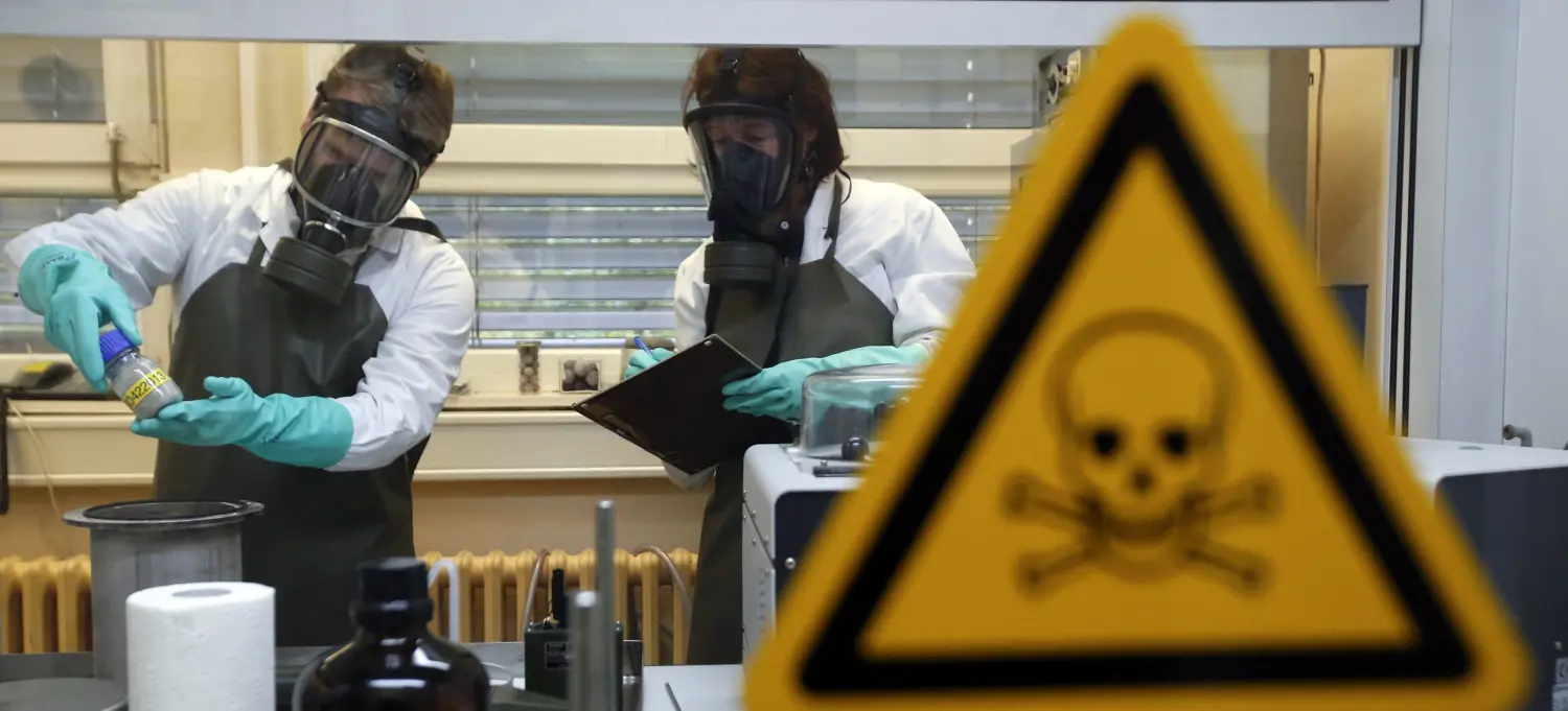 Employees of the Research Institute for Protective Technologies, Nuclear, Biological and Chemical Protection (WIS) inspect a dummy sample which is contaminated with a substance similar to the chemical weapon Sarin, during a demonstration in Munster October 15, 2013. The state-owned WIS is a reference laboratory for the Organisation for the Prohibition of Chemical Weapons (OPCW). Picture taken October 15, 2013. REUTERS/Fabrizio Bensch (GERMANY - Tags: MILITARY SCIENCE TECHNOLOGY) - BM2E9AG10D501