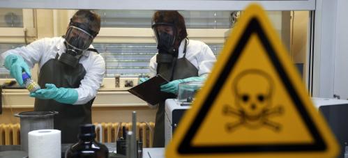 Employees of the Research Institute for Protective Technologies, Nuclear, Biological and Chemical Protection (WIS) inspect a dummy sample which is contaminated with a substance similar to the chemical weapon Sarin, during a demonstration in Munster October 15, 2013. The state-owned WIS is a reference laboratory for the Organisation for the Prohibition of Chemical Weapons (OPCW). Picture taken October 15, 2013. REUTERS/Fabrizio Bensch (GERMANY - Tags: MILITARY SCIENCE TECHNOLOGY) - BM2E9AG10D501