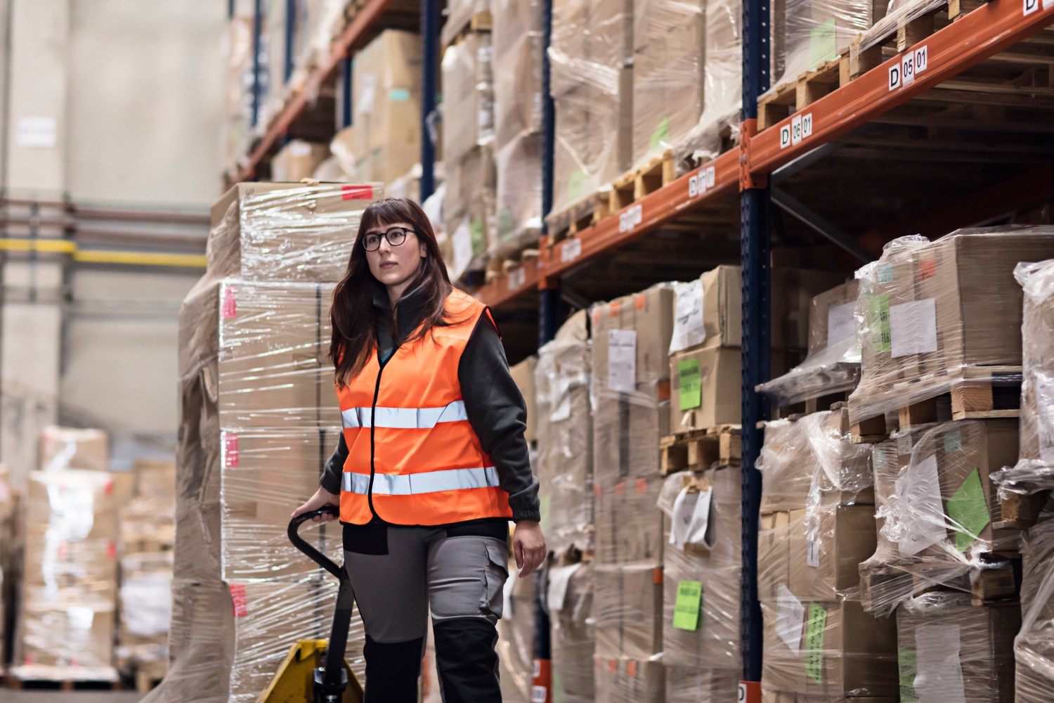 Young woman moving boxes in a warehouse.