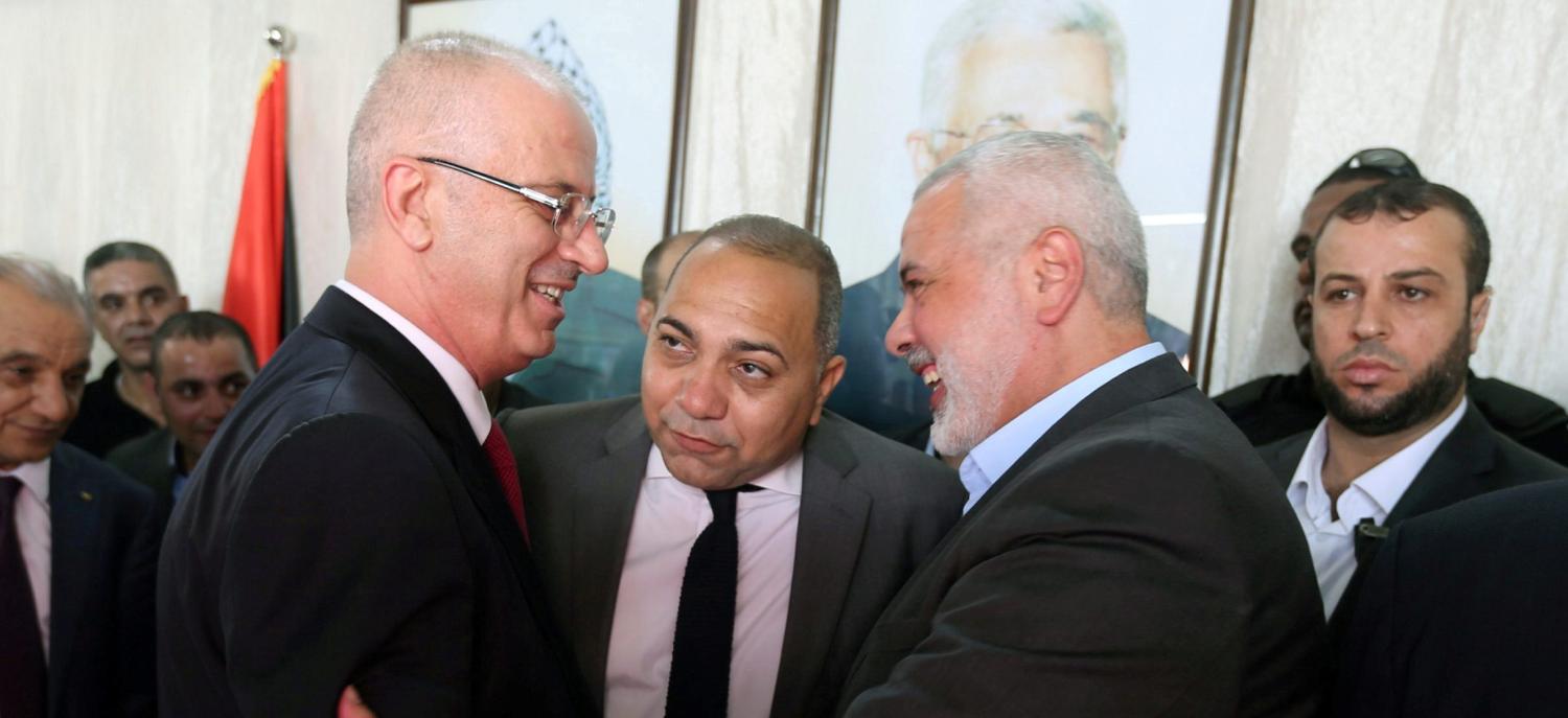 Palestinian Prime Minister Rami Hamdallah (L) shakes hands with Hamas Chief Ismail Haniyeh in Gaza City October 2, 2017. REUTERS/Ibraheem Abu Mustafa TPX IMAGES OF THE DAY - RC1A1BA640D0