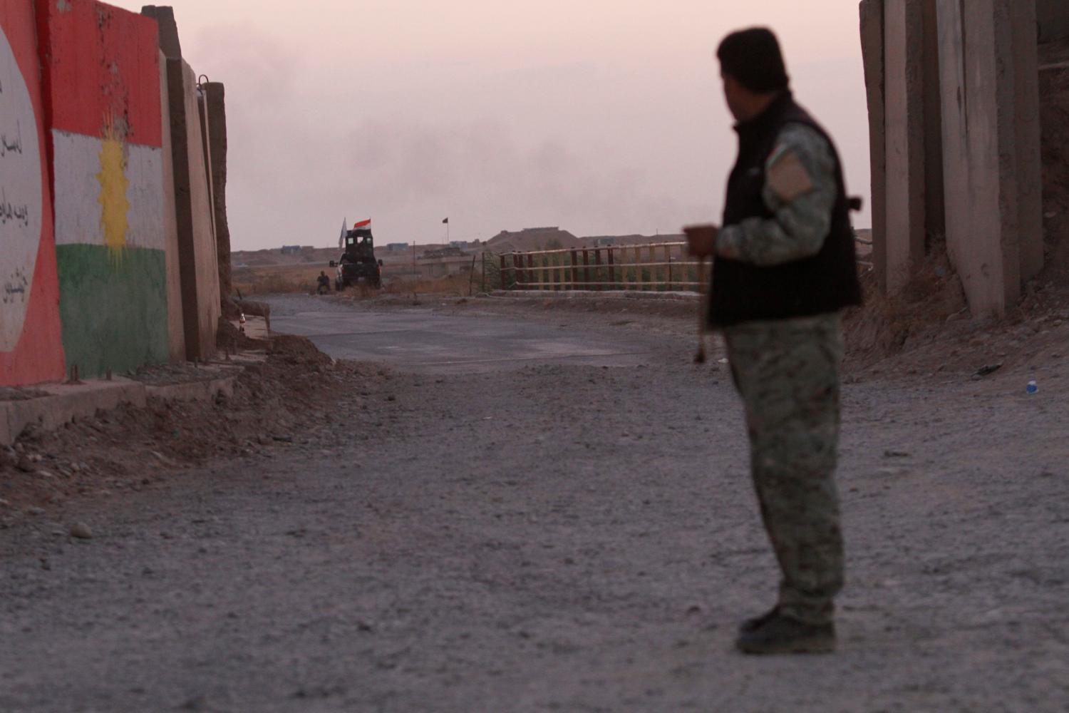 A Kurdish Peshmerga fighter looks at the Shi'ite Popular Mobilization Forces (PMF) in the Southwest of Kirkuk, Iraq October 13, 2017.