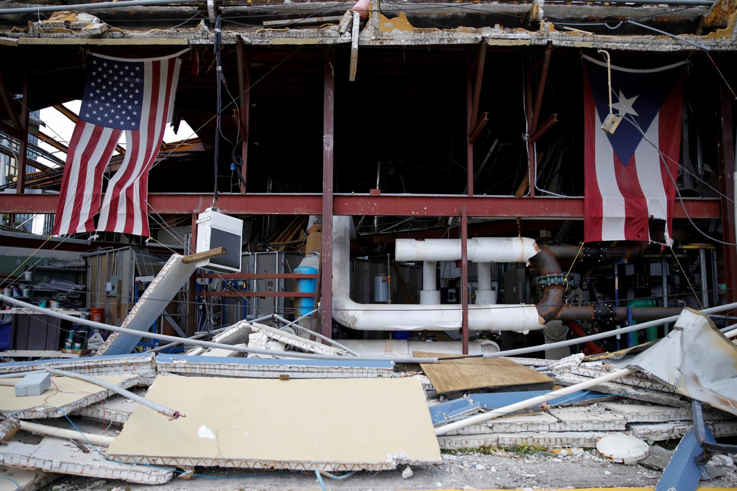 Photo: U.S. and Puerto Rico flags hang on a damaged church after the area was hit by Hurricane Maria in Carolina, Puerto Rico September 26, 2017. REUTERS/Carlos Garcia Rawlins TPX IMAGES OF THE DAY - RC1602BA2AC0