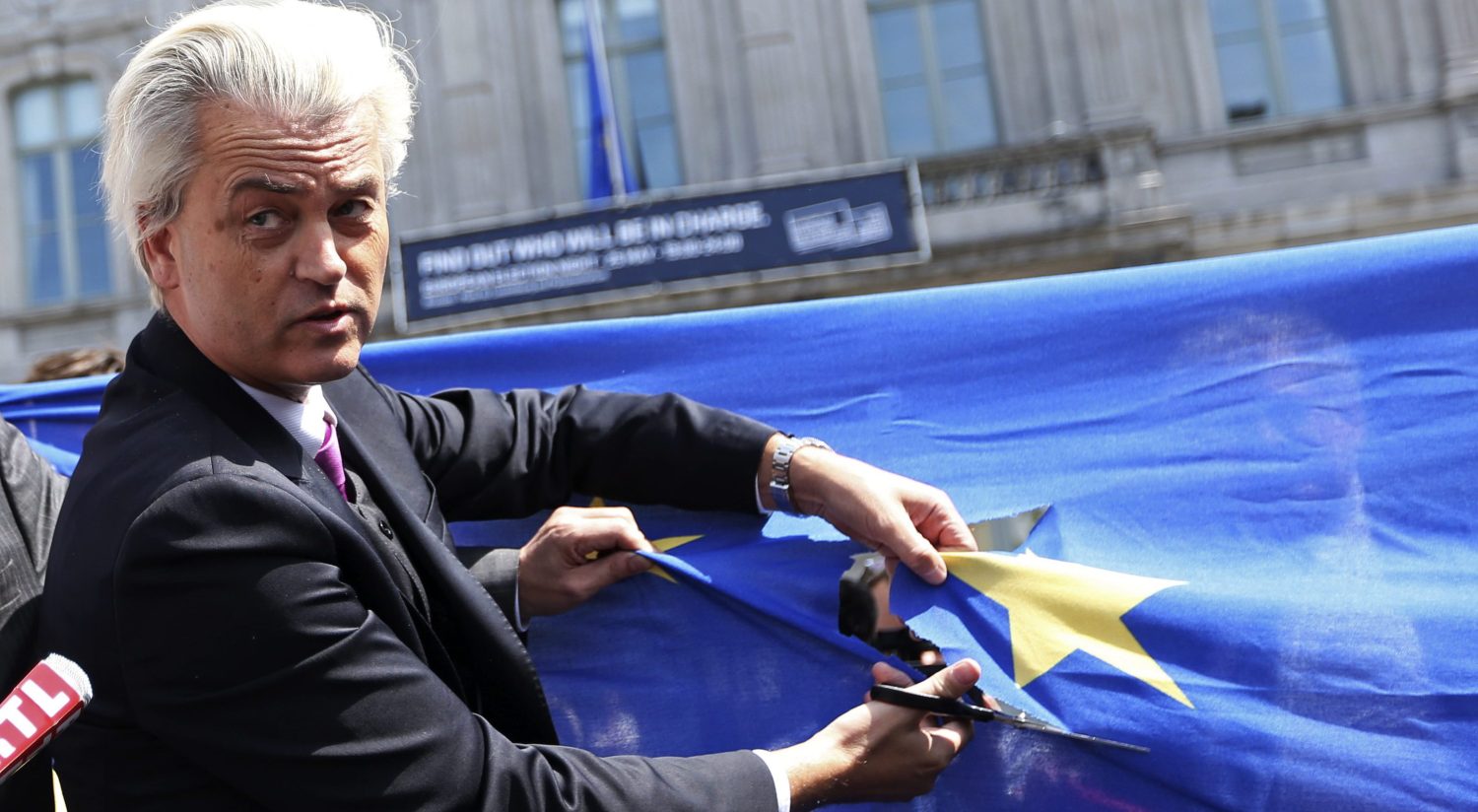 Dutch far-right Freedom Party (PVV) leader Geert Wilders cuts a star from the European Union flag during a demonstration in front of the EU Parliament in Brussels May 20, 2014.