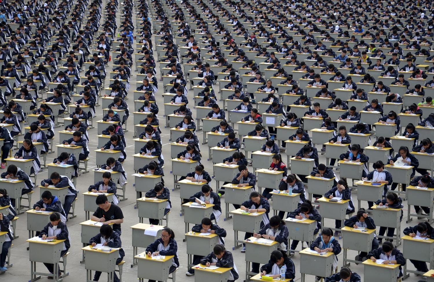 Students take an examination on an open-air playground at a high school in Yichuan