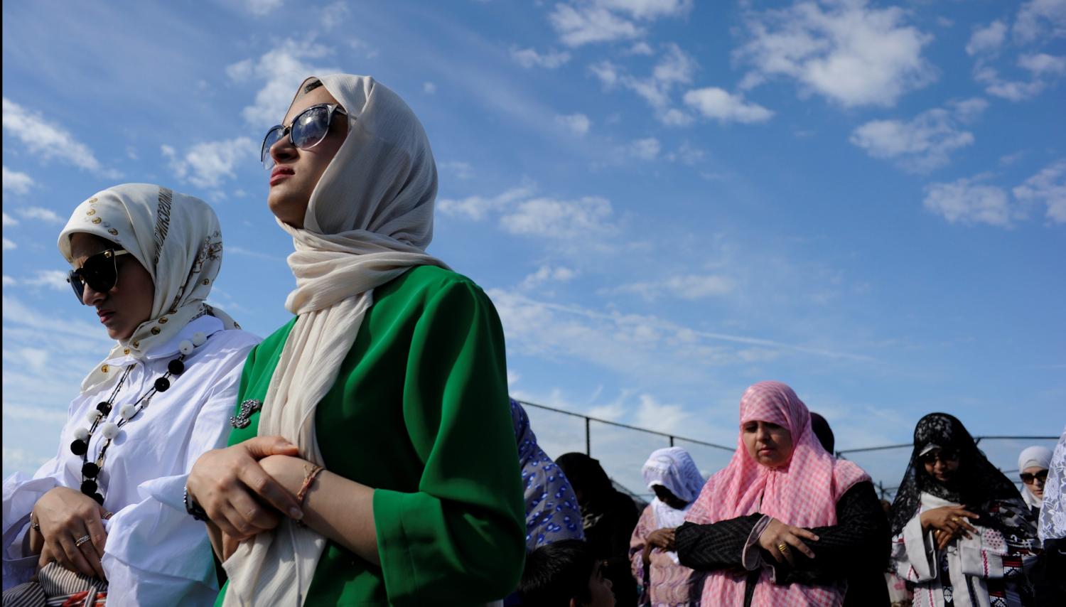 Yemeni-American Muslim sisters Hajar Udayni (L) and Sara Udayni Udayni take part in Eid al-Fitr prayers in Brooklyn, New York, U.S., June 25, 2017. REUTERS/Kholood Eid - RC169CD80CC0