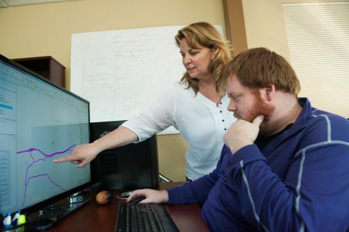 Elizabeth Vreswyk, founder and president of AWTY Logistics, talks to GIS technician Brock Kralicek in the company's office in Dickinson, North Dakota