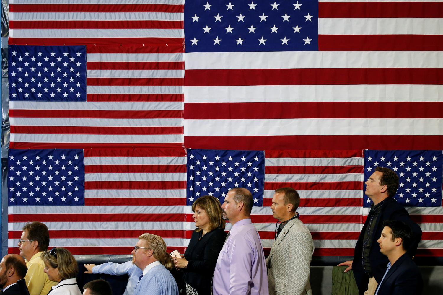 People listen as U.S. President Donald Trump speaks about tax reform.