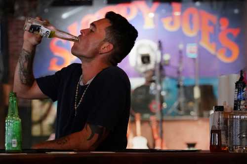 A man finishes his beer at a mostly empty Sloppy Joe's bar.