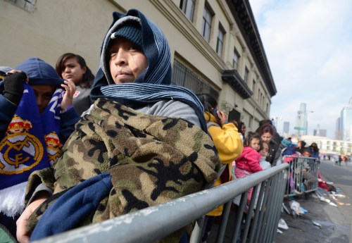 Children and families wait in line, as holiday gifts and toys are distributed to underprivileged children at the Fred Jordan Mission in Los Angeles.