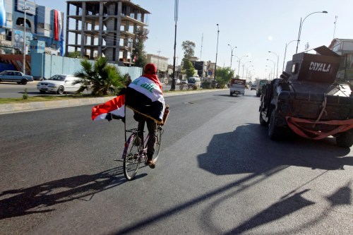 A man rides a bicycle with Iraqi flag in north of Kirkuk, Iraq October 19, 2017. Picture taken October 19, 2017. REUTERS/Ako Rasheed - RC1A98800B10