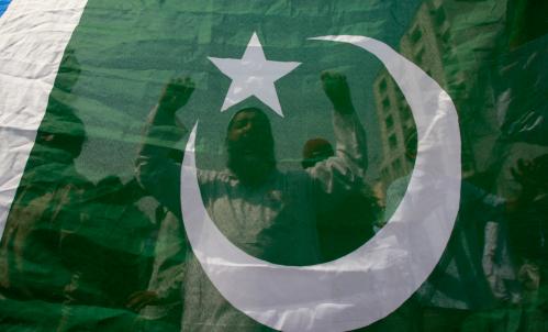 Activists of Pakistan's Islamist party Jamaat-e-Islami chant slogans behind a flag during countrywide anti-government protest rally in Karachi March 12, 2009. Pakistani lawyers and opposition activists launched a cross-country protest on Thursday, heading for a showdown with the civilian government which has banned rallies and detained hundreds of activists. REUTERS/Athar Hussain (PAKISTAN CONFLICT POLITICS) - GM1E53C1OGP01