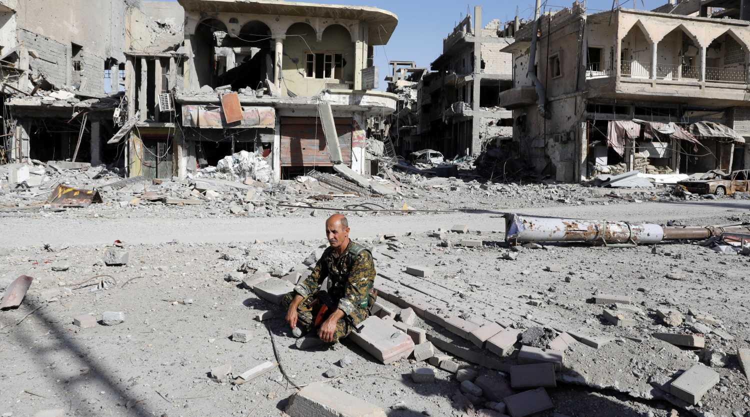 A fighter of Syrian Democratic Forces rests on rubble after Raqqa was liberated from the Islamic State militants, in Raqqa, Syria October 17, 2017. Picture taken October 17, 2017. REUTERS/Erik De Castro - RC1DA42C9EF0