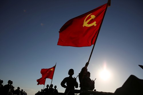 Soldiers carry a Chinese Communist Party flag and Chinese national flags before the military parade to commemorate the 90th anniversary of the foundation of China's People's Liberation Army (PLA) at Zhurihe military base in Inner Mongolia Autonomous Region