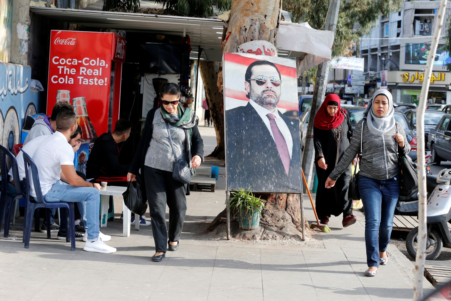 People walk next to a poster depicting Lebanon's Prime Minister Saad al-Hariri, who has resigned from his post, along a street in the mainly Sunni Beirut neighbourhood of Tariq al-Jadideh in Beirut, Lebanon November 6, 2017. REUTERS/Mohamed Azakir - RC1556EE7010