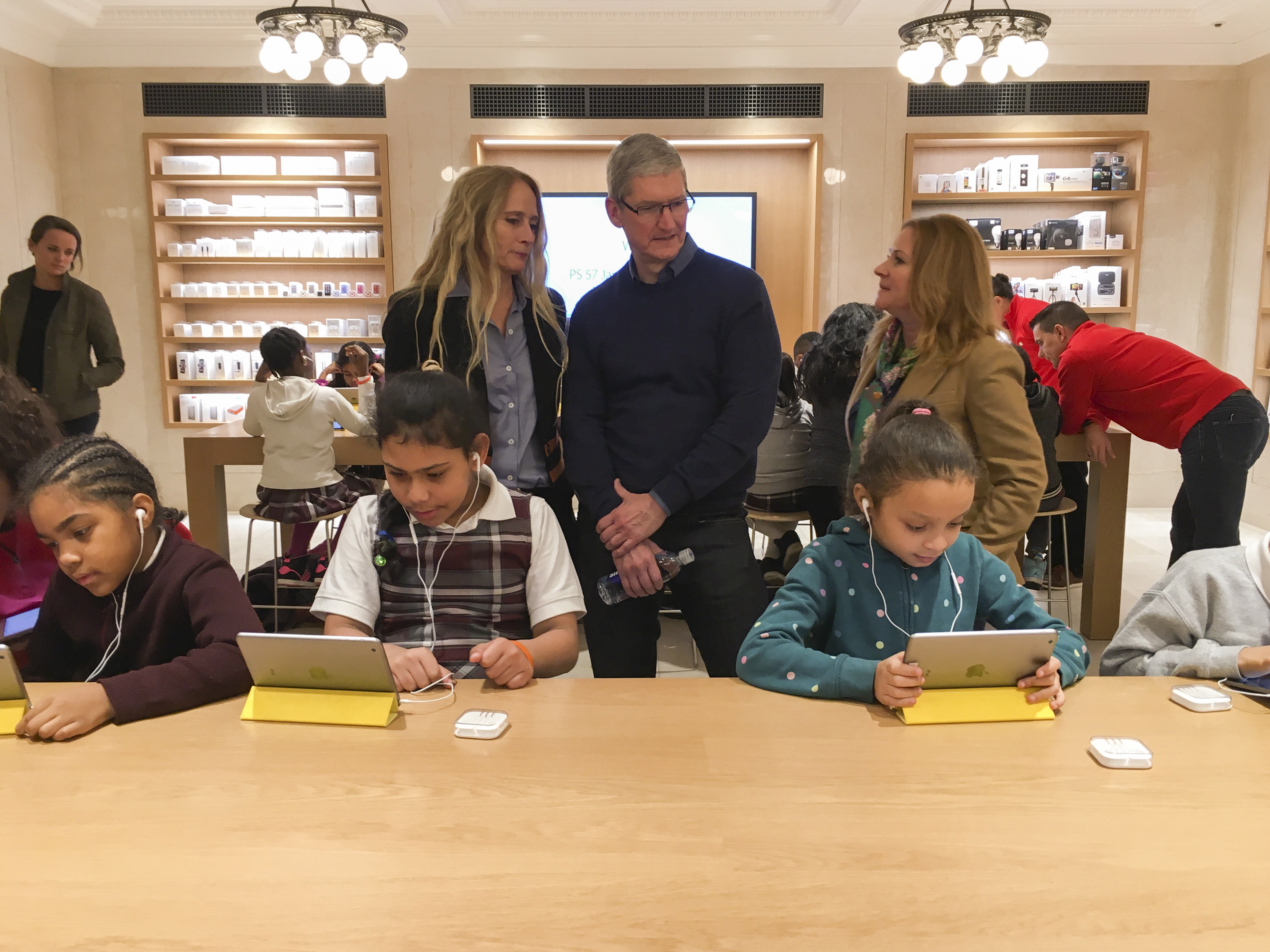 Apple Chief Executive Officer Tim Cook (C) attends an event for students to learn to write computer code at the Apple store in the Manhattan borough of New York December 9, 2015.     REUTERS/Carlo Allegri - GF10000260390