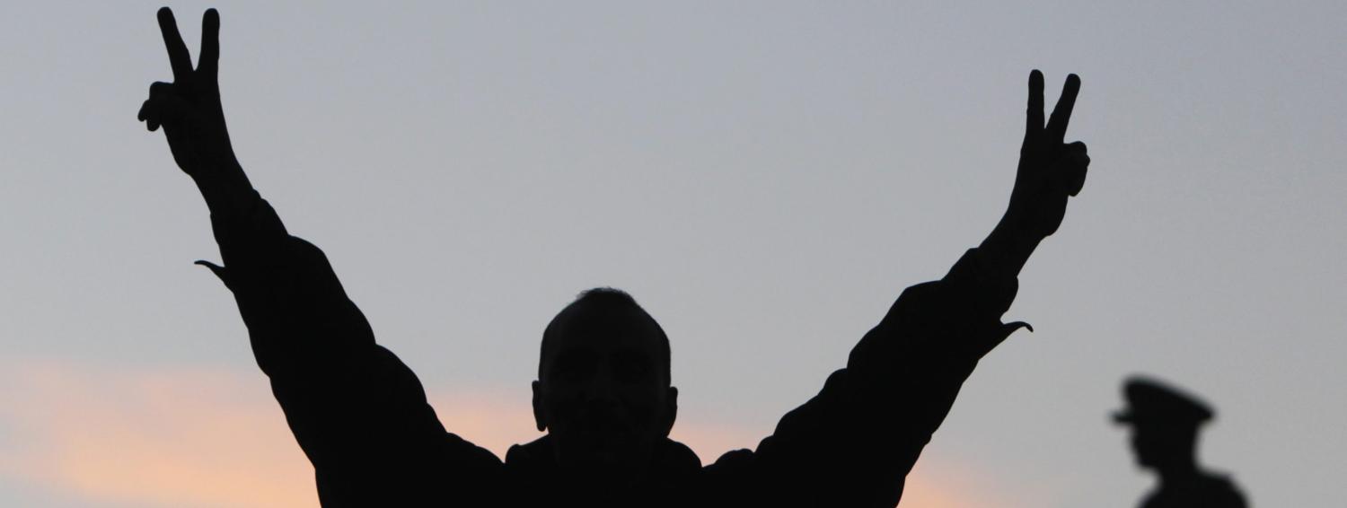 A supporter of the constitution gestures in front of a statue of Egypt's former Army Chief of Staff Abdel Moneim Riad near Tahrir square, during the final stage of a referendum on Egypt's new constitution in Cairo, January 15, 2014. Polls across Egypt closed on Wednesday evening after a second and final day of voting on a draft constitution that could pave the way for a presidential bid by army chief General Abdel Fattah al-Sisi. Voting passed off more peacefully than on Tuesday, when nine people were killed, but officials said police arrested at least 79 people on Wednesday during protests by supporters of deposed President Mohamed Mursi, removed from power by Sisi in July. REUTERS/Mohamed Abd El Ghany