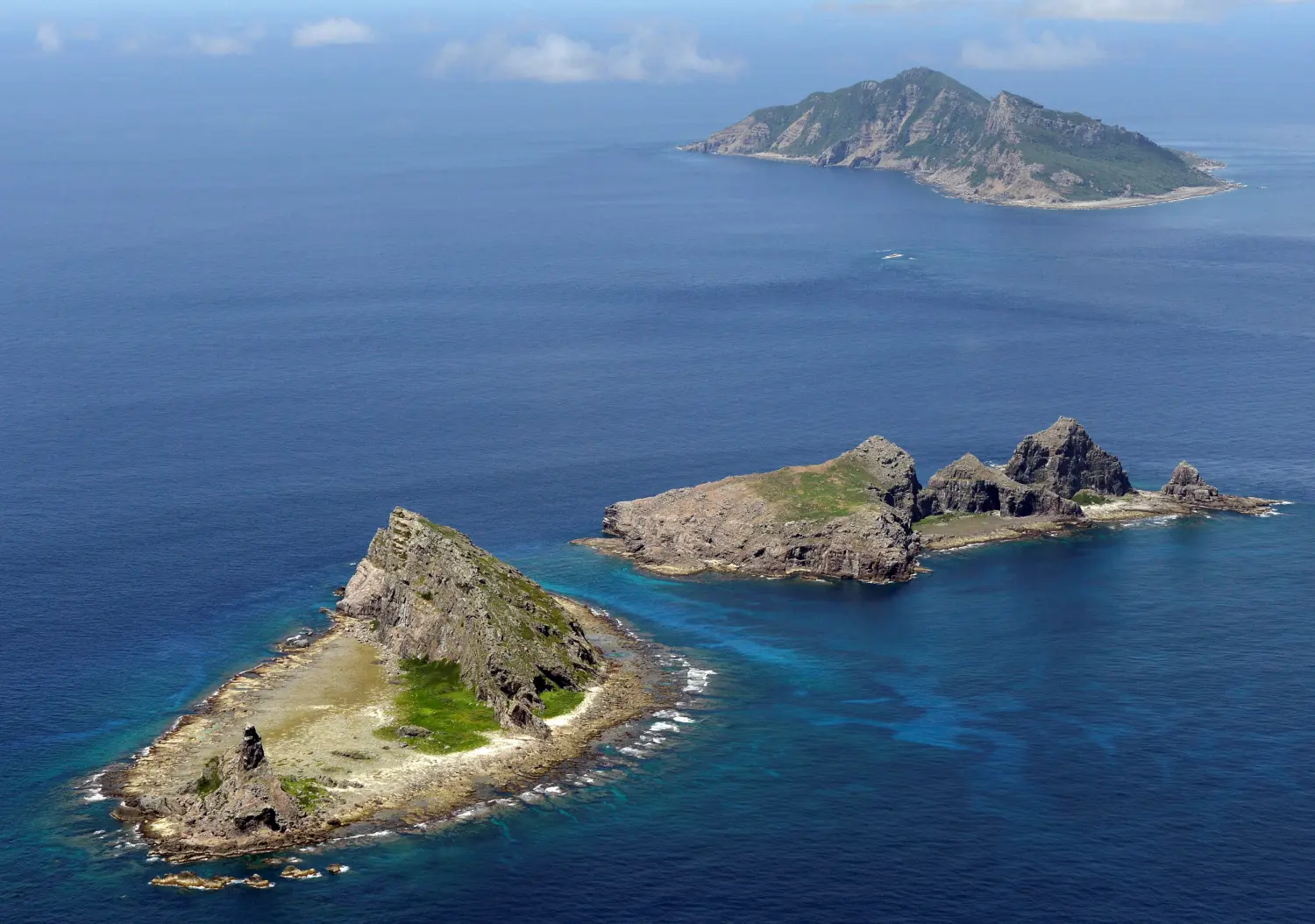 A group of disputed islands, Uotsuri island (top), Minamikojima (bottom) and Kitakojima, known as Senkaku in Japan and Diaoyu in China is seen in the East China Sea, in this photo taken by Kyodo September 2012.