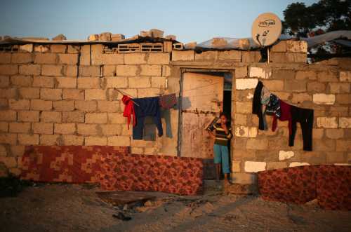 A Palestinian girl stands outside her family house in Khan Younis in the southern Gaza Strip November 27, 2017. REUTERS/Ibraheem Abu Mustafa - RC129439E380