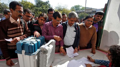 Polling officials wait to receive Voter Verifiable Paper Audit Trail (VVPAT) machines and Electronic Voting Machines (EVM) at a distribution centre ahead of the final phase of voting in Gujarat state assembly election in Ahmedabad, India, December 13, 2017. REUTERS/Amit Dave - RC1F07DFD550