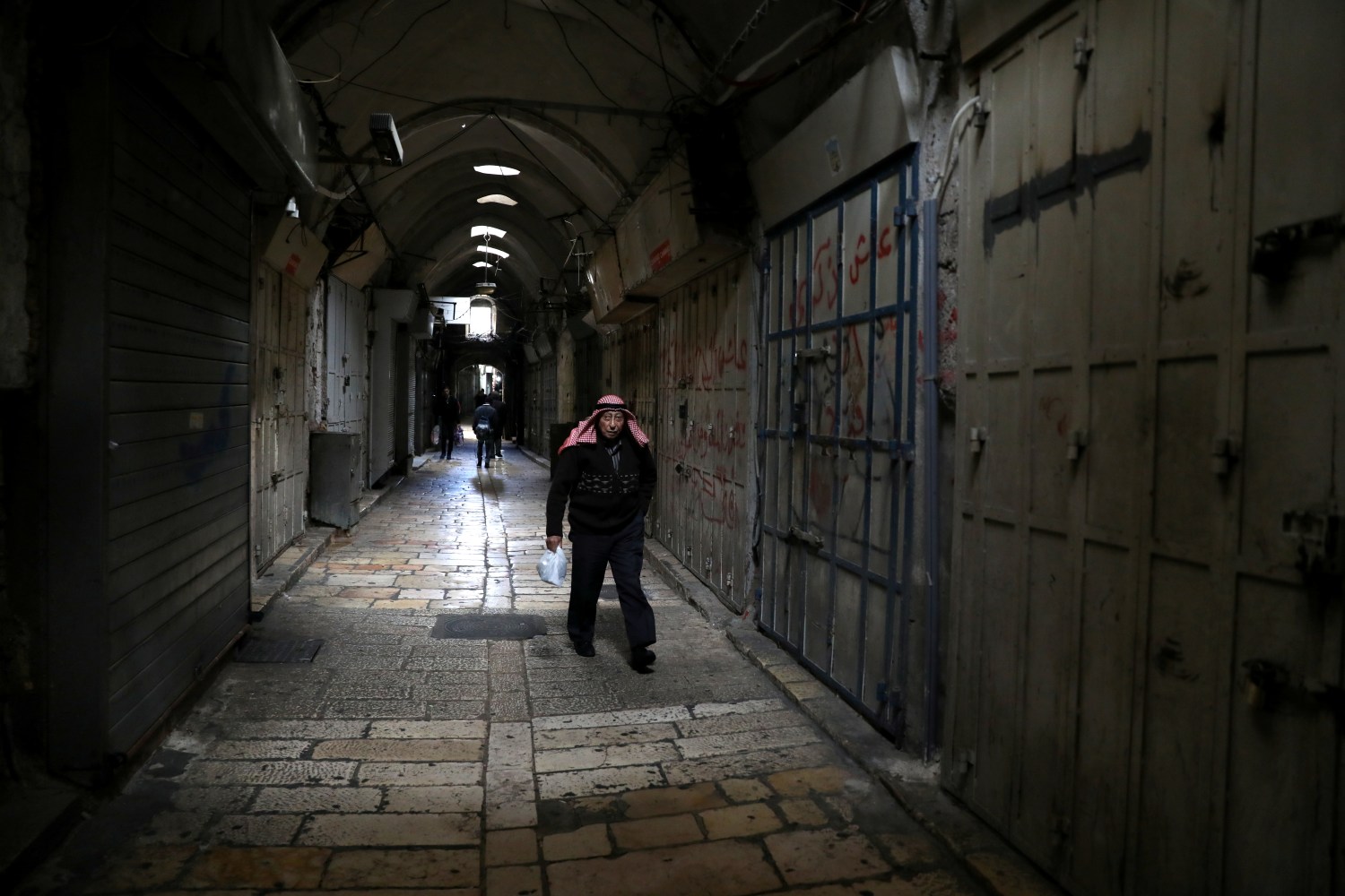 A Palestinian man walks past closed shops after Palestinian secular and Islamist factions called a general strike to protest U.S. President Donald Trump's announcement that he has recognized Jerusalem as Israel's capital, in Jerusalem's Old City December 7, 2017. REUTERS/Ammar Awad - RC178CF28F50