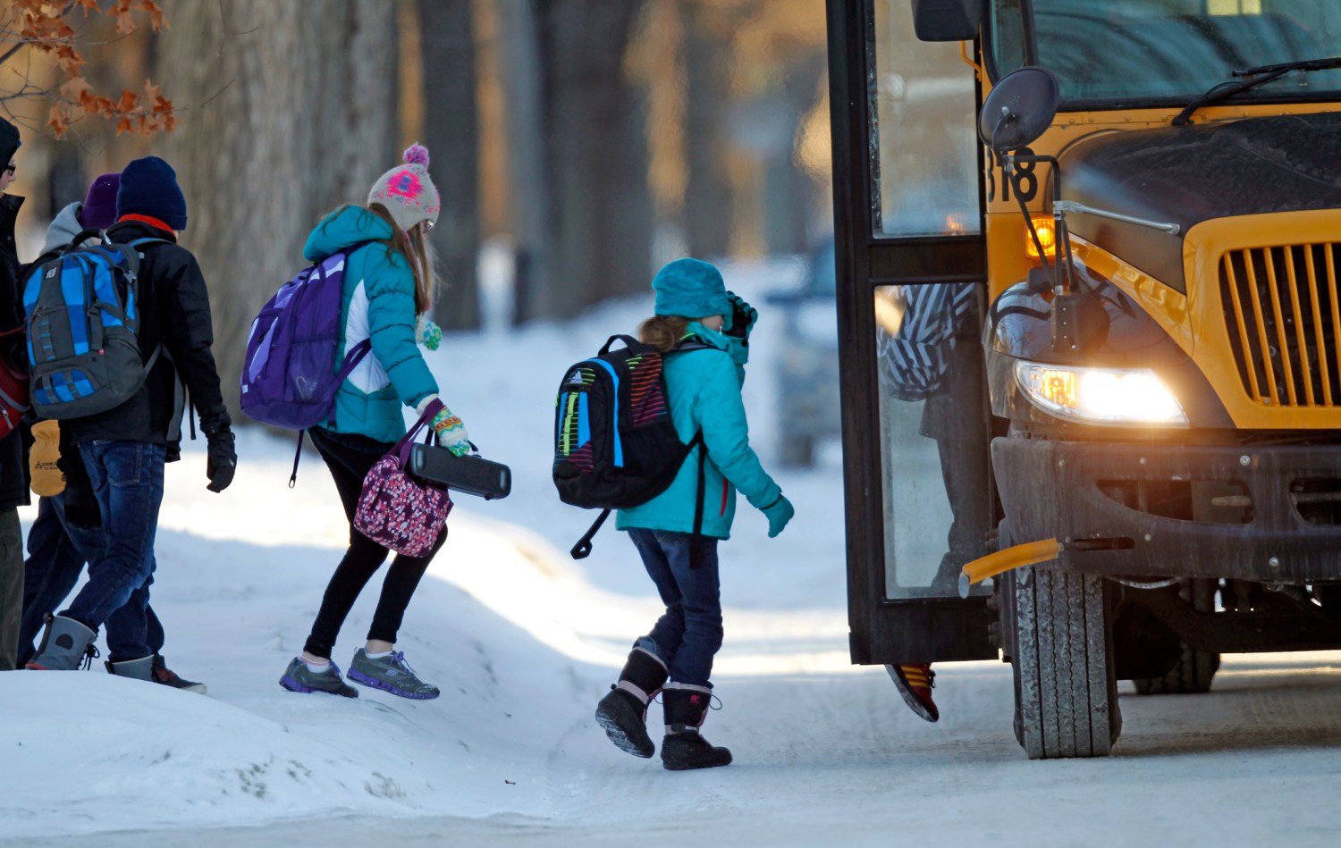 Students board their school bus in a sub-zero temperature.