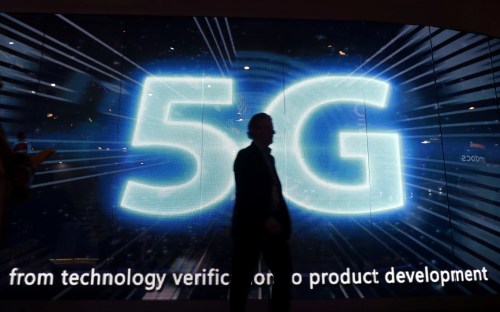 A visitor walks past a 5G sign