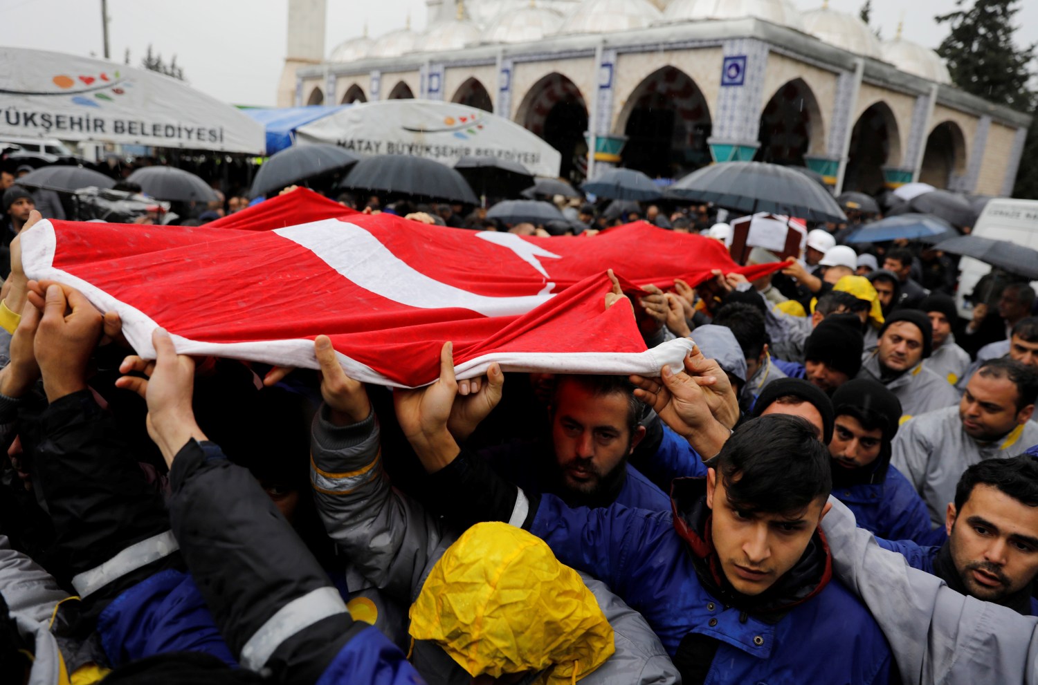 Relatives and friends of Sahin Elitas, a civilian who was killed in a rocket attack fired by Syria, carry a Turkish flag during his funeral ceremony in the town of Kirikhan in Hatay province, Turkey January 23, 2018.