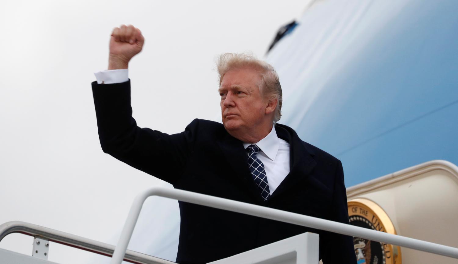 U.S. President Donald Trump pumps his fist as he boards Air Force One upon departure from Joint Base Andrews in Maryland