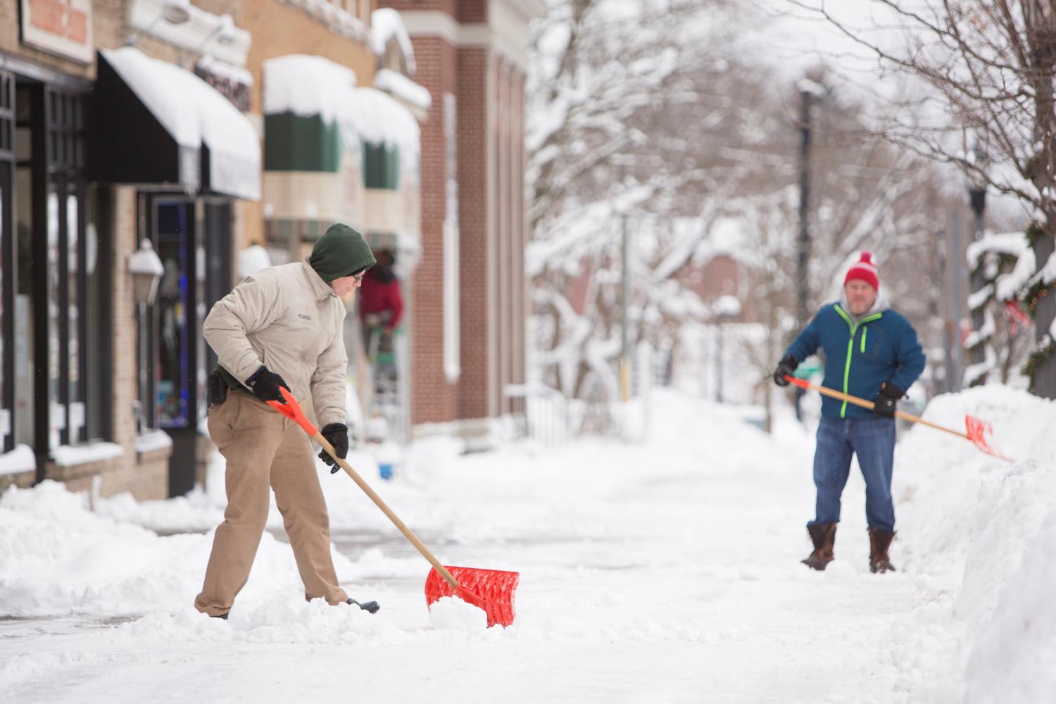 People shovel snow during the first lake effect snowfall of the season.