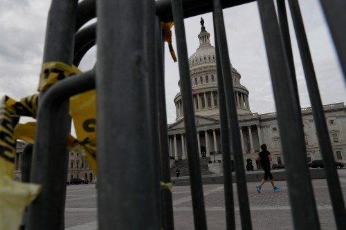 A jogger runs past the U.S. Capitol during the third day of a government shutdown.
