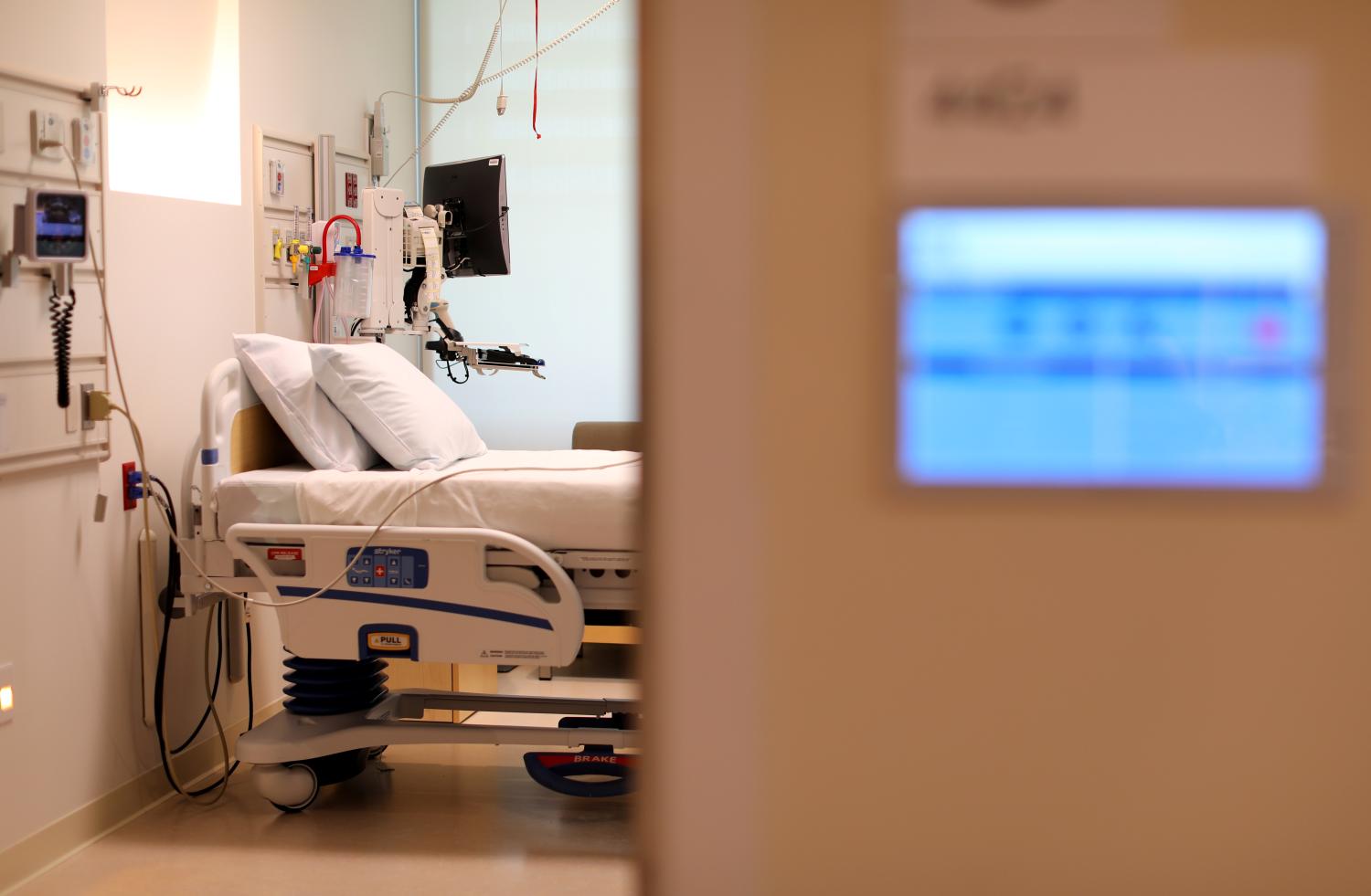 An electronic patients chart is shown on the wall to a hospital room.