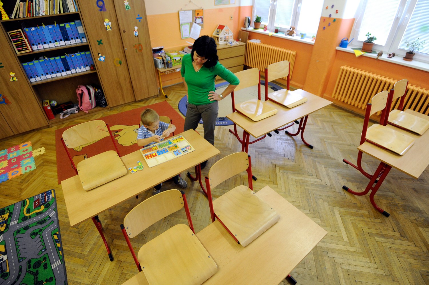 Kindergarden student Misko (4) plays with puzzles next to a teacher and volunteer in an empty school, closed during a one-day strike by local teachers seeking higher salaries and better work conditions.