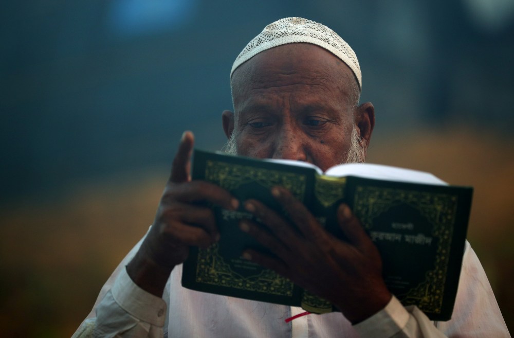 A Rohingya refugee reads the Quran during sunrise in Balukhali refugee camp near Cox's Bazar, Bangladesh, October 26, 2017. REUTERS/Hannah McKay - RC1E91534850