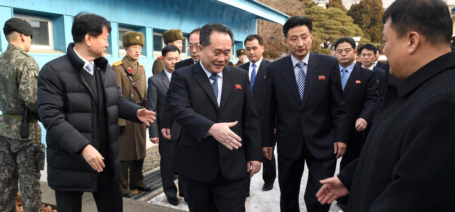 Head of North Korean delegation Ri Son Gwon, Chairman of the Committee for the Peaceful Reunification of the Country (CPRC) of DPRK, reaches out to shake hands with a South Korean official as he crosses a concrete border to attend their meeting at the truce village of Panmunjom in the demilitarised zone separating the two Koreas, South Korea, January 9, 2018. REUTERS/Korea Pool - RC11892B1F30