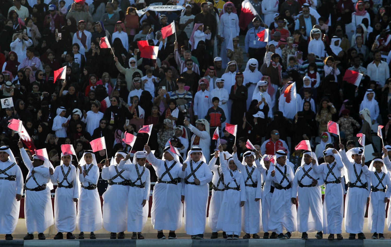 Boys hold Qatari flags as they take part in Qatar's National Day celebrations in Doha, Qatar, December 18, 2017. REUTERS/Naseem Zeitoon