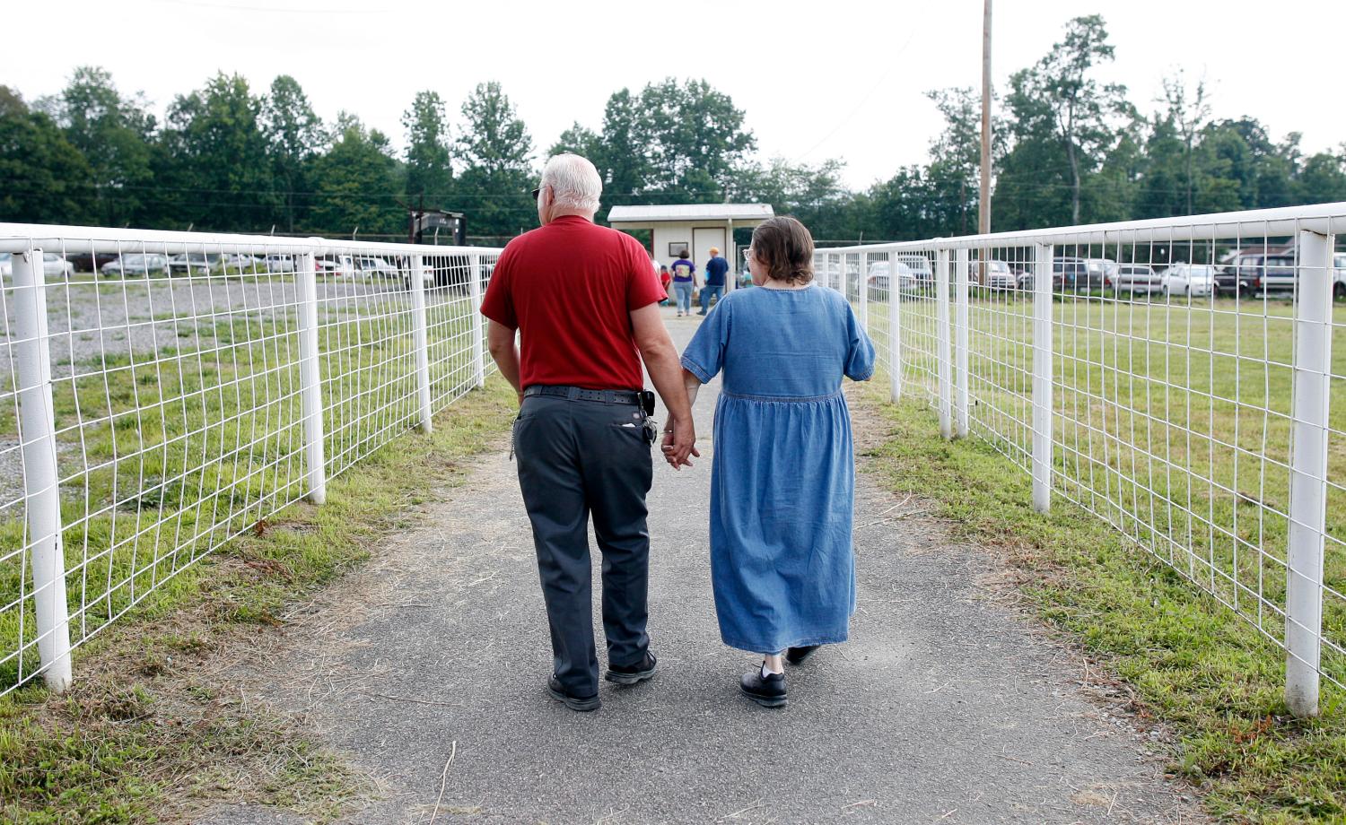 A couple leaves the Remote Area Medical (RAM) health clinic at the Wise County Fairgrounds in Wise, Virginia July 24, 2009. The free clinic, which lasts 2 1/2 days, is the largest of its kind in the nation providing medical, dental and vision services from more than 1,400 medical volunteers. For many residents of this Appalachian area, the RAM clinic serves as the only medical care they may receive each year. REUTERS/Shannon Stapleton