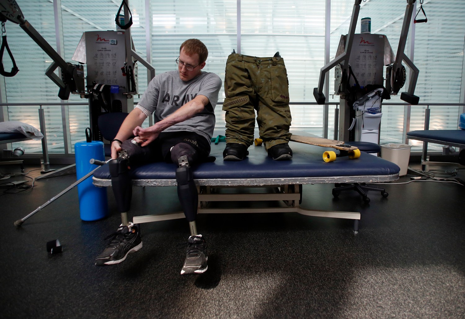 Sgt. Matt Krumwiede prepares to put on prosthetic legs to practice riding his longboard at the Center for the Intrepid at Brooke Army Medical Center in San Antonio, Texas, February 24, 2014. Krumwiede was on patrol in Afghanistan in 2012 when he stepped on an improvised explosive device which tore away both his legs, damaged his left arm, and ripped open his abdominal cavity. Since then he has undergone dozens of surgeries and spent time recovering at Brooke Medical Center in San Antonio, Texas, learning to walk again with the use of prosthetic legs. In June 2014, he visited to his hometown of Pocatello, Idaho for the first time since he was injured. Picture taken February 24, 2014. REUTERS/Jim Urquhart (UNITED STATES - Tags: MILITARY HEALTH POLITICS CIVIL UNREST TPX IMAGES OF THE DAY) ATTENTION EDITORS: PICTURE 24 OF 35 FOR PACKAGE 'KANDAHAR TO IDAHO - A LIFE IN RECOVERY' TO FIND ALL IMAGES SEARCH 'MATT KRUMWIEDE' - GM1EA7O158C01