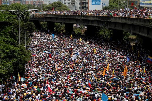 Demonstrators march during the so-called "mother of all marches" against Venezuela's President Nicolas Maduro in Caracas, Venezuela, April 19, 2017. Carlos Garcia Rawlins: "That day was one of the biggest rallies up to then. There were thousands of people trying to find their way to the office of the state ombudsman after gathering in more than two dozen points around Caracas. But as in previous rallies, they were blocked by the National Guard. Waving the country's yellow, blue and red flag and shouting 'No more dictatorship' and 'Maduro out,' demonstrators clogged a stretch of the main highway in Caracas. I remember the desperation of the people trying to escape the tear gas and not having space to run because there were so many." REUTERS/Carlos Garcia Rawlins/File Photo SEARCH "POY VENEZUELA" FOR THIS STORY. SEARCH "REUTERS POY" FOR ALL BEST OF 2017 PACKAGES. TPX IMAGES OF THE DAY. - RC1DC4F53B10