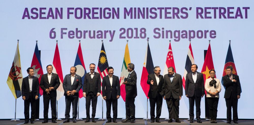 Foreign ministers prepare to pose for a group photo at the Association of Southeast Asian Nations (ASEAN) Foreign Ministers' Meeting retreat in Singapore February 6
