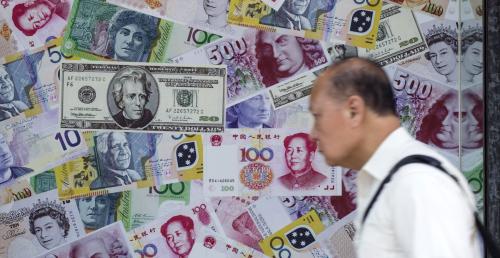 A man walks past an advertisement promoting China's renminbi (RMB) or yuan, U.S. dollar and Euro exchange services at foreign exchange store in Hong Kong, China, August 13, 2015. German Bund yields edged up on Thursday following efforts by China's central bank to slow a sharp descent of the yuan that has prompted investors this week to seek safe-haven assets. REUTERS/Tyrone Siu - GF10000172716
