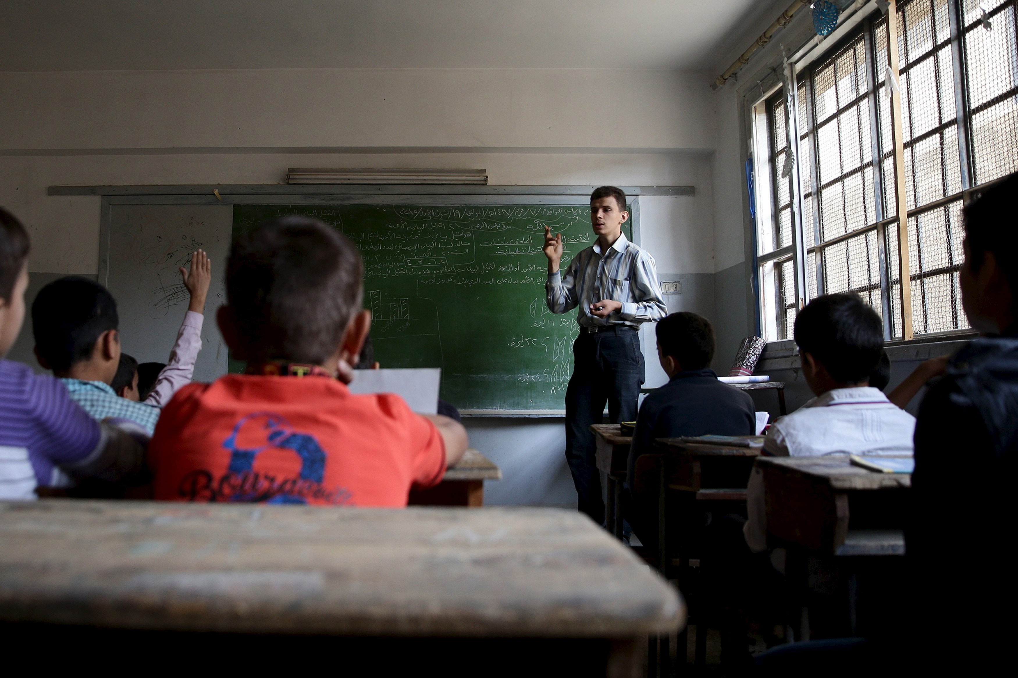 Students attend a class inside a school in a rebel-controlled area of the eastern Ghouta of Damascus, Syria October 19, 2015. The new school year in eastern Ghouta of Damascus was postponed several time this year due to airstrikes by forces loyal to Syria's President Bashar al-Assad on the area in the last weeks, activists said. REUTERS/Bassam Khabieh  - GF10000250802