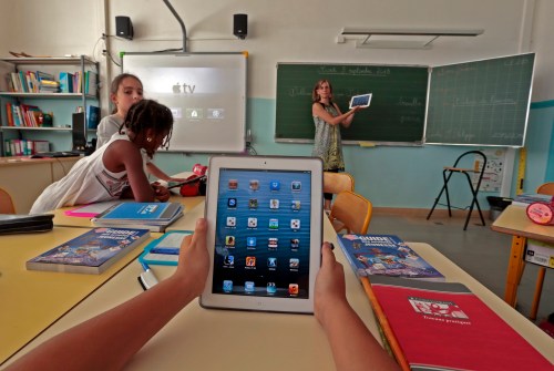Elementary school children use electronic tablets