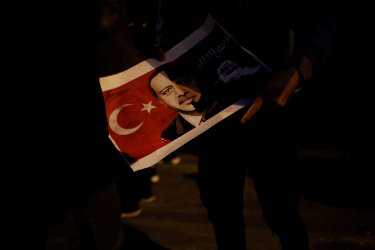 A Kurd living in Greece holds a poster depicting Turkish President Recep Tayyip Erdogan during a demonstration against the Turkish offensive on Kurdish forces in northwest Syria, in Athens, Greece, January 23, 2018. REUTERS/Alkis Konstantinidis - RC16FB9E79B0