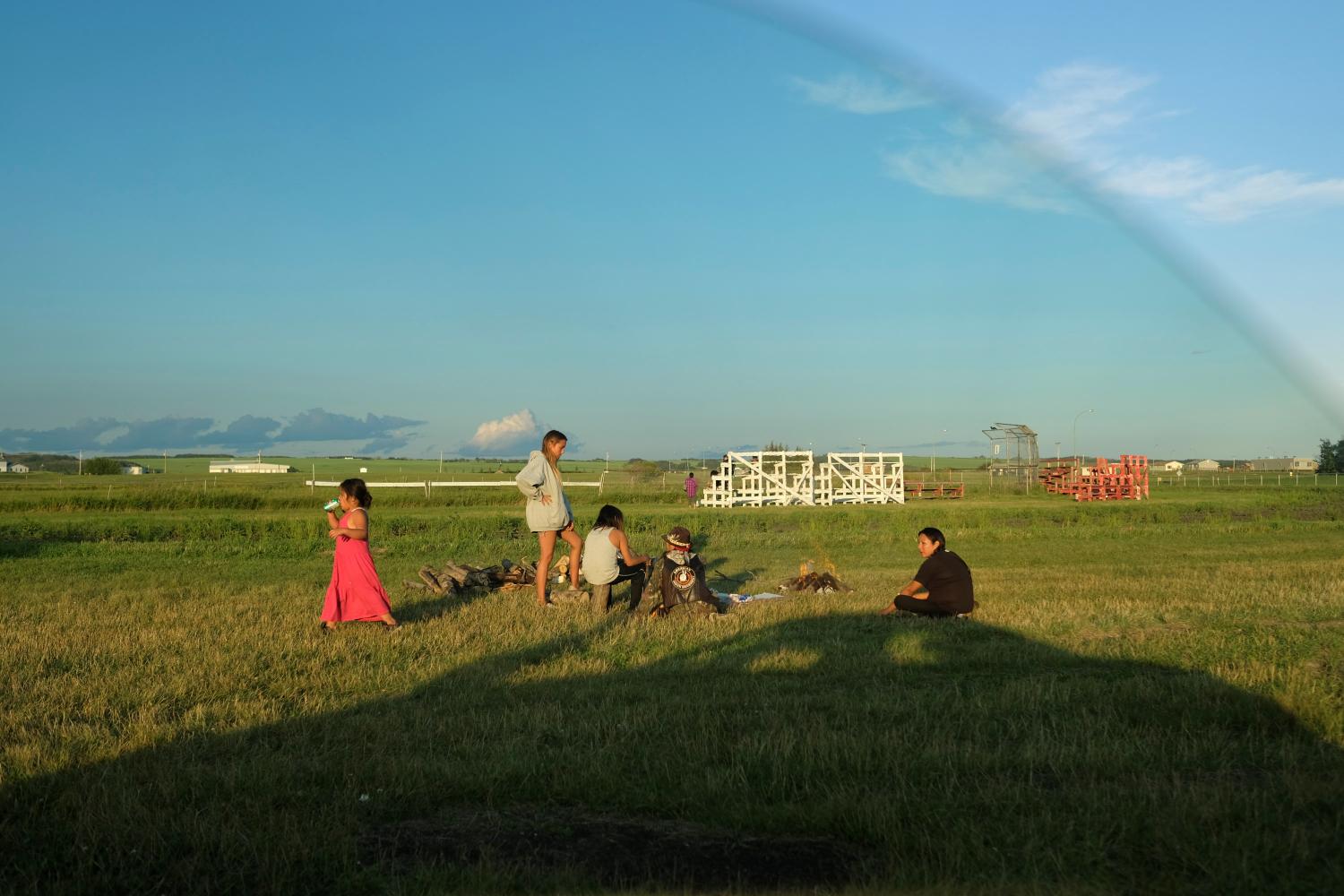 People gather around a fire on the campground set up by the First Nations Indigenous Warriors (FNIW) and the American Indian Movement (AIM) on the Cote First Nation, near the town of Kamsack, Saskatchewan