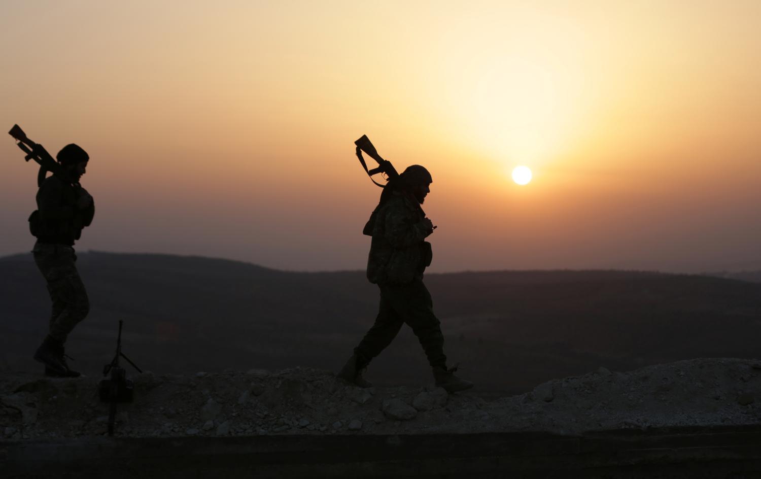 Turkish-backed Free Syrian Army fighters walk as the sun sets in Eastern Afrin countryside, Syria, February 6, 2018. REUTERS/Khalil Ashawi - RC1E12B5E3F0