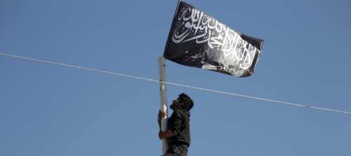 A member of al Qaeda's Nusra Front climbs a pole where a Nusra flag was raised at a central square in the northwestern city of Ariha, after a coalition of insurgent groups seized the area in Idlib province May 29, 2015. A Syrian insurgent alliance which has captured the last government-held town in the northwestern Idlib province made further advances on Friday, a monitoring group and fighters said. REUTERS/Khalil Ashawi - GF10000111523