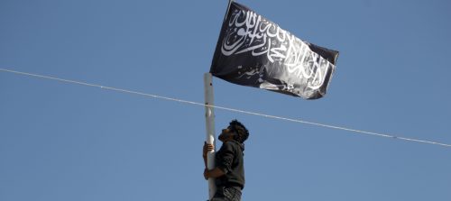 A member of al Qaeda's Nusra Front climbs a pole where a Nusra flag was raised at a central square in the northwestern city of Ariha, after a coalition of insurgent groups seized the area in Idlib province May 29, 2015. A Syrian insurgent alliance which has captured the last government-held town in the northwestern Idlib province made further advances on Friday, a monitoring group and fighters said. REUTERS/Khalil Ashawi - GF10000111523
